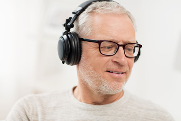 Obraz premium happy man in headphones listening to music at home