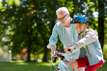 grandfather and boy with bicycle at summer park