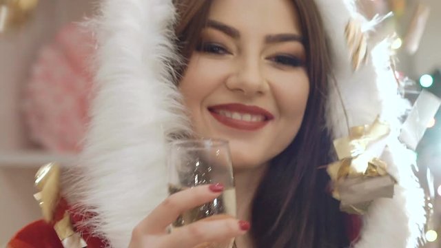 Funny girl dances, drinks a bocal of champagne in throwing glitter. Slowly