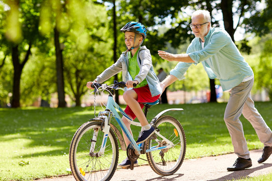 grandfather and boy with bicycle at summer park