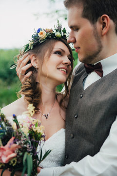 portrait of a bride and groom embrace on  background  leaves  forest