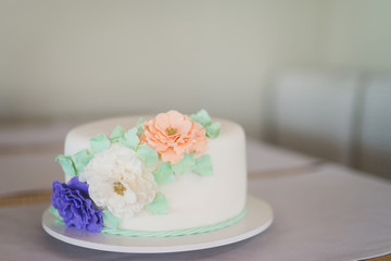white cake with blue, green and orange decorative flowers