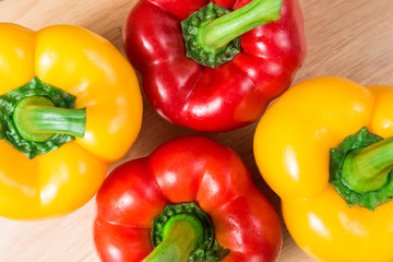 group of red and yellow sweet pepper on a wooden block