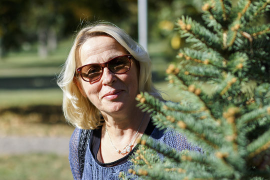 Portrait of senior woman with sunglasses in park.