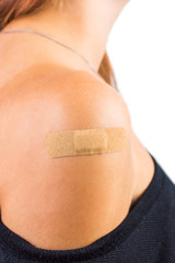 medical plaster on her shoulder. On white, isolated background.