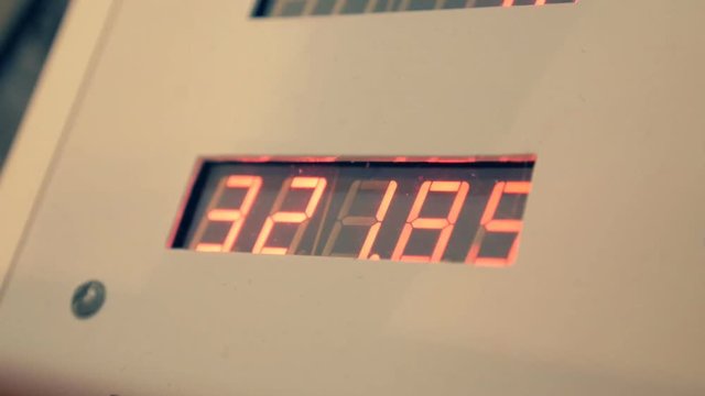 Digital meter with glowing red numbers, counting. A digital counter counts the gallons, gasoline and petrol