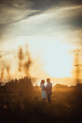 Obraz na płótnie Canvas love story man and woman on the background of haystacks sun