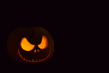 Halloween pumpkin with scary face on black background