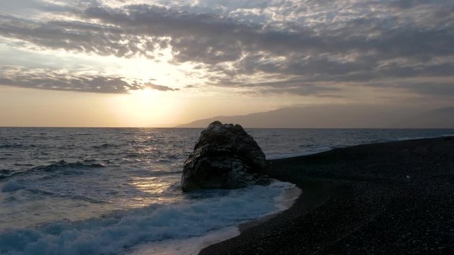 View of Waves Rolled at Sea Coast Line With Huge Rock at Sunset