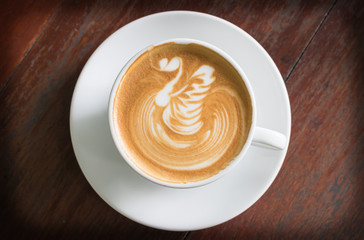 Top view coffee cup latte art on wood table.