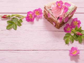 pink rose and cake on wooden background