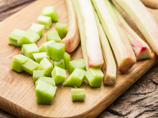 Edible rhubarb stalks on the wooden table.