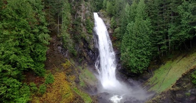 Flying Towards Flowing Waterfalls in Cascade Mountains Forest