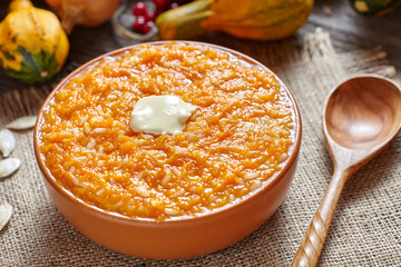 Vegan pumpkin rice porridge pudding breakfast homemade sweet baked dessert healthy organic diet food with butter traditional autumn meal on vintage table background