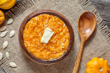 Seasonal pumpkin rice porridge pudding breakfast homemade sweet baked dessert healthy organic nutrition diet food with butter traditional autumn meal on vintage table background