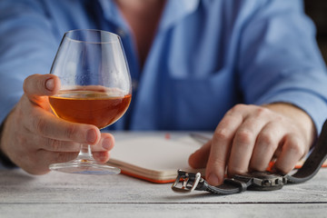 cute young man drinks whiskey at table