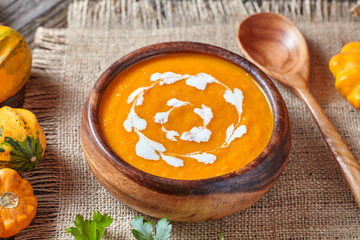 Pumpkin soup traditional spicy vegetarian autumn vegetable healthy organic diet creamy homemade food meal on vintage wooden table background