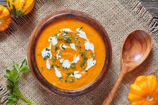 Cream of roasted pumpkin spicy soup traditional simple vegetarian autumn vegetable healthy organic diet homemade food meal on vintage wooden table background