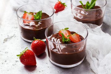 Chocolate mousse with strawberries in glass on rustic table