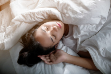 Obraz premium Cute girl on a soft white bed. She sleeping and relaxing.
