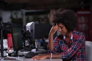 Fototapeta na wymiar a young African American woman feels tired in the modern office