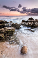 Waves crashing over rocks at sunset on the coast of Trafalgar.