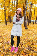 Portrait of a beautiful girl on the background of autumn trees