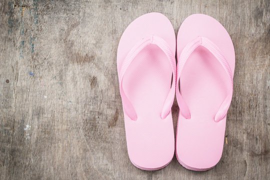 Flip-flops pink color on a wooden background.