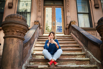 Woman with phone in the New York city posing