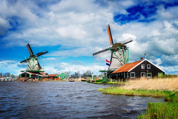 Naklejka premium two traditional Dutch windmills of Zaanse Schans, Netherlands, retro toned