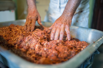 Man making sausages the traditional way using sausage filler.