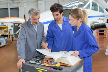 Engineers looking through manual