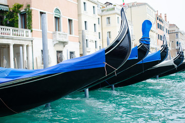 Fototapeta na wymiar Gondolas in Venice on the Grand Canal, Italy. Moored gondolas to the pier of San Marco in Venice.