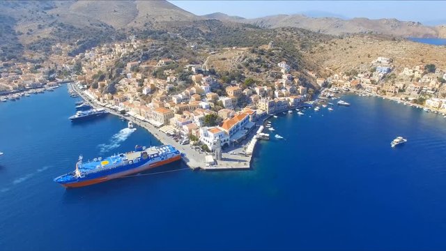 Symi island - Aerial footage of Colorful houses and small boats at the heart of the village