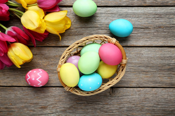 Obraz na płótnie Canvas Easter eggs with tulips on a grey wooden table