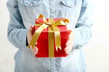 Female hands holding gift box with ribbon