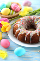 Easter eggs with cake on a blue wooden table