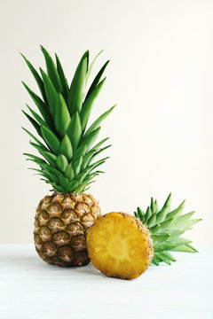 Ripe pineapples on a white wooden background