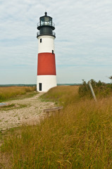 Fototapeta na wymiar Active lighthouse on a grassy cliff on a north Atlantic barrier island