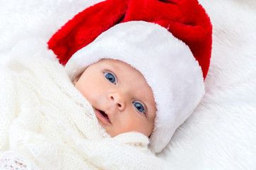 Portrait of a baby girl with blue eyes wearing Santa hat  