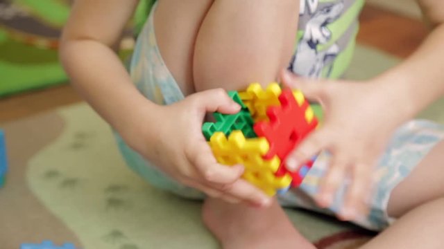 Little boy plays with constructor on the floor