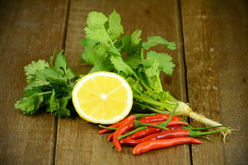 Coriander leaves, Lime and Red Pepper on Wooden Table.