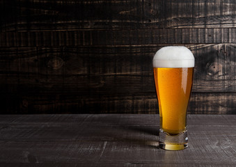 Glass of beer with frost frost on wood background