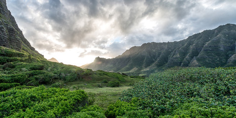 Sunset Between lush green Hawaiian valley with Moody sky