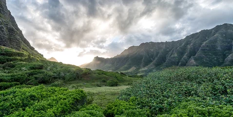 Fototapeten Sunset Between lush green Hawaiian valley with Moody sky © Motion Vista Media