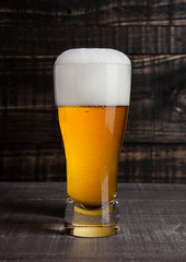 Glass of beer with frost frost on wood background