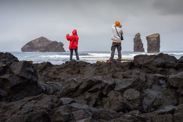 Couple of tourists photographing the Mosteiros Volcanic Beach, Sao Miguel, Azores, Portugal