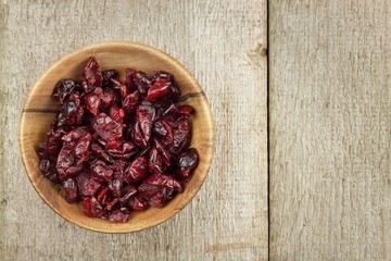Dried cranberries in a bowl. Healthy superfood. Dried cranberries on the kitchen table. Diet food.
