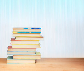 Colorful books on a wooden table.