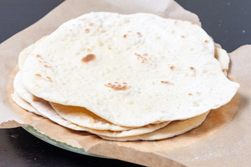 A stack of rotis on a sheet of baking parchment